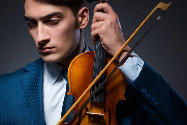 Jovem tocando violino no quarto escuro — Fotografia de Stock