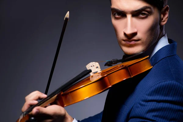 Ung man spelar fiol i mörkrummet — Stockfoto