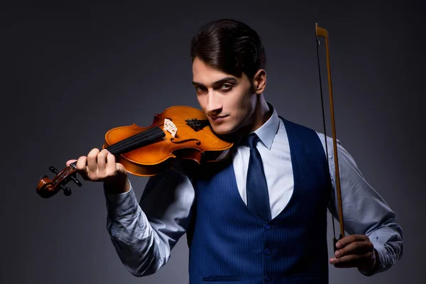 Young man playing violin in dark room — Stock Photo, Image