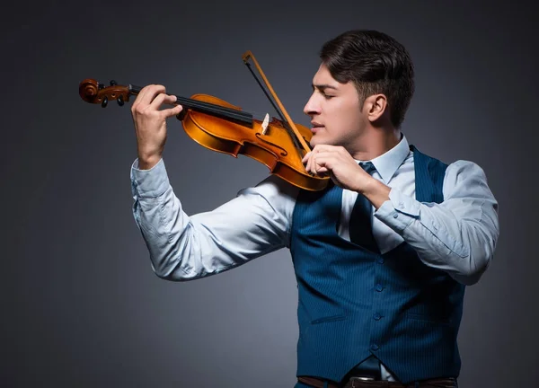 Ung man spelar fiol i mörkrummet — Stockfoto