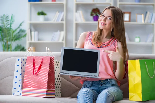 若いです女性でショッピングバッグ屋内ホームオンソファ — ストック写真