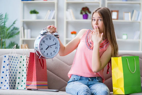 Mladá žena s nákupními taškami doma na pohovce — Stock fotografie