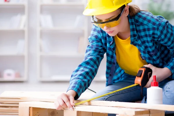 Female repairman carpenter cutting joining wooden planks doing r — Stock Photo, Image