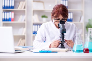 Bir laboratuarda deney yapan kadın bir bilim adamı.