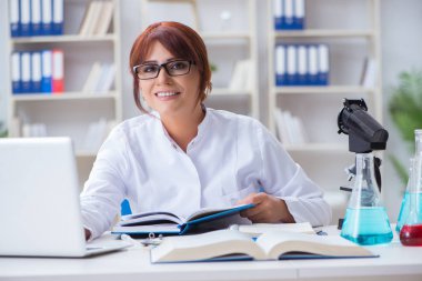 Bir laboratuarda deney yapan kadın bir bilim adamı.