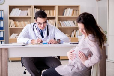 Hamile kadın muayene için doktoru ziyaret ediyor.
