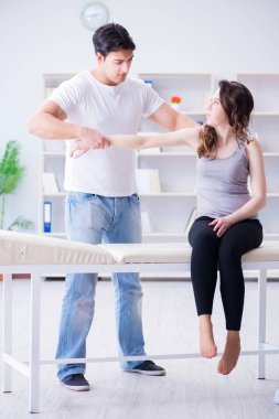 Genç doktor kayropraktik uzmanı kadın hastaya masaj yapıyor.