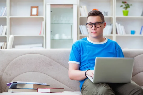 Estudiante joven preparándose para los exámenes que estudian en casa en un sofá — Foto de Stock