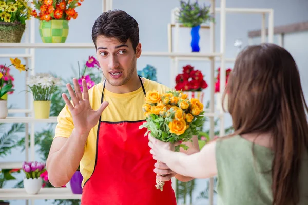 Çiçekçi dükkanında çiçek satıyor.