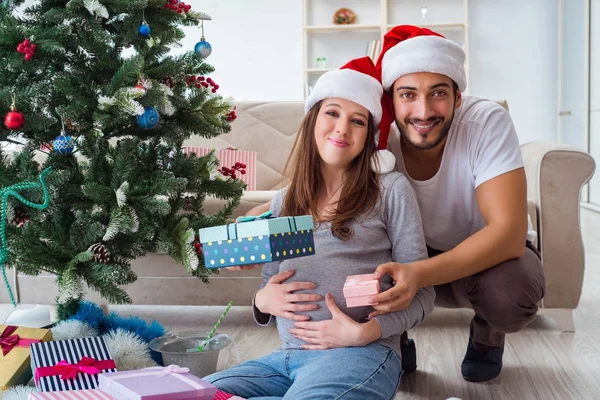 Junge Familie erwartet Baby und feiert Weihnachten — Stockfoto