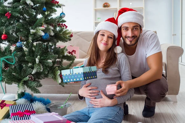 Jeune famille attend bébé célébrant Noël — Photo