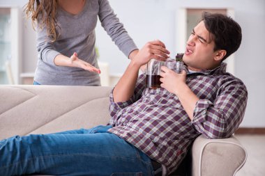 Genç bir aile kavramında içki sorunu yaşayan sarhoş bir koca.