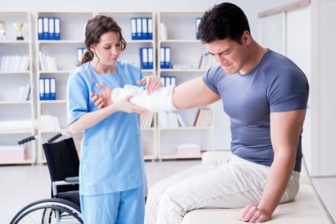Hastanede yaralanma kontrolü sırasında doktor ve hasta.
