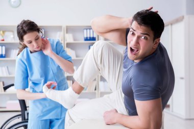 Hastanede yaralanma kontrolü sırasında doktor ve hasta.