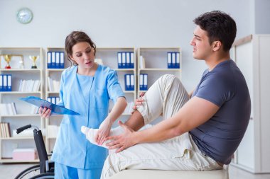 Hastanede yaralanma kontrolü sırasında doktor ve hasta.