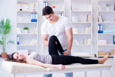 Genç doktor kayropraktik uzmanı kadın hastaya masaj yapıyor.