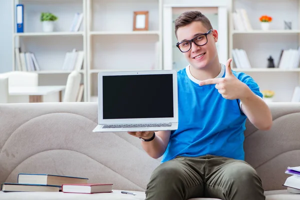 Giovane studente che si prepara per gli esami studiando a casa su un divano — Foto Stock