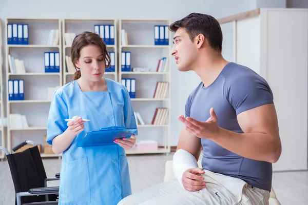 Hastanede yaralanma kontrolü sırasında doktor ve hasta.