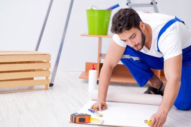 Tamirci, duvar kağıdıyla evde tadilat yapıyor.