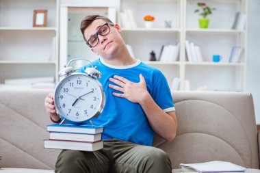 Sınavlara hazırlanan genç öğrenci kanepede ders çalışıyor.