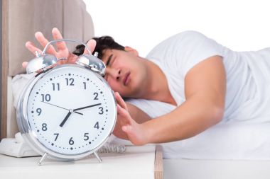 Yatakta uykusuzluk çeken bir adam.