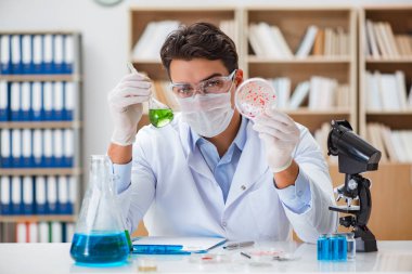 Laboratuvarda virüs aşısı üzerinde çalışan erkek doktor.