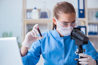 Bir laboratuarda deney yapan kadın bir bilim adamı.