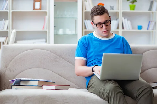 Ung student förbereder sig för tentor studera hemma i en soffa — Stockfoto