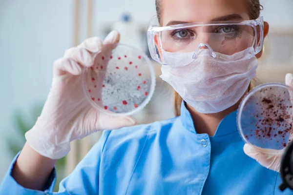 Bir laboratuarda deney yapan kadın bir bilim adamı.