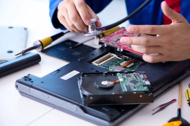 Bilgisayar dizüstü bilgisayarının tamirinde çalışan tamirci.