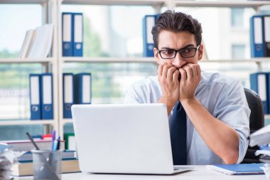 Ofiste çalışan aşırı çalışma evrakları olan bir iş adamı.