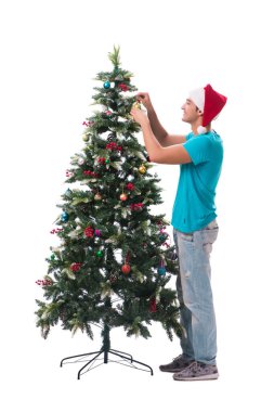 Genç adam beyaz üzerine izole edilmiş noel ağacını süslüyor.