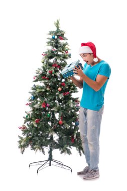Genç adam beyaz üzerine izole edilmiş noel ağacını süslüyor.