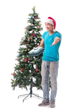 Genç adam beyaz üzerine izole edilmiş noel ağacını süslüyor.