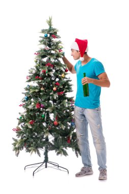 Genç adam beyaz üzerine izole edilmiş noel ağacını süslüyor.