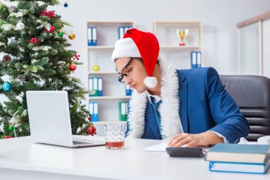 İş adamı Noel tatilini ofiste kutluyor.