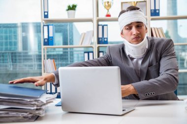 Injured businessman working in the office clipart
