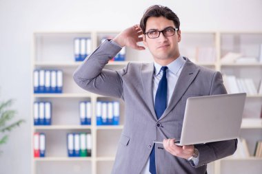 Ofisteki iş adamı dizüstü bilgisayarla çalışıyor.