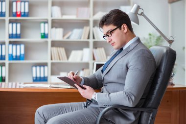 Ofiste çalışan genç bir işadamı.