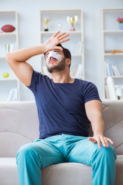 Genç adam estetik cerrahi burnundan sonra evde iyileşiyor.