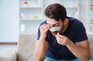 Genç adam estetik cerrahi burnundan sonra evde iyileşiyor.