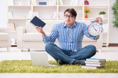 Genç yakışıklı adam evde yerde oturuyor.