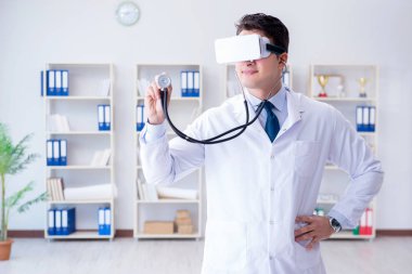 Sanal gerçeklik kulaklığı olan genç doktor ofiste çalışıyor.