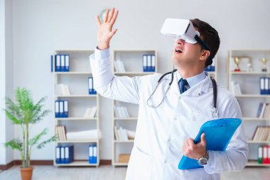 Sanal gerçeklik kulaklığı olan genç doktor ofiste çalışıyor.