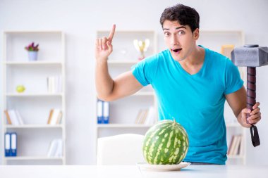 Evde karpuz yiyen bir adam.