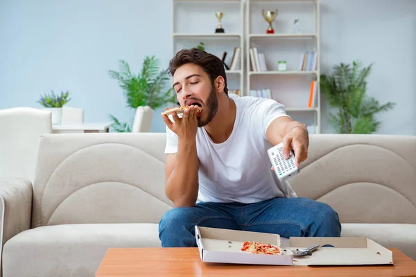 Man eten pizza met een afhaalmaaltijd thuis ontspannen rusten — Stockfoto
