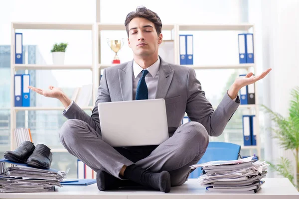 Businessman sitting on top of desk in office — Stock Photo, Image