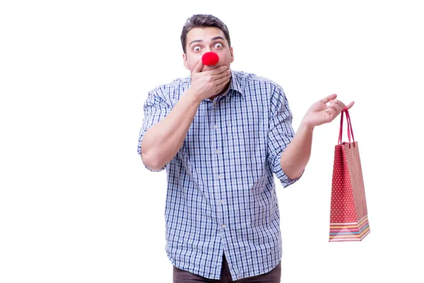 El hombre con una nariz roja divertida sosteniendo un regalo de bolsa de compras es —  Fotos de Stock