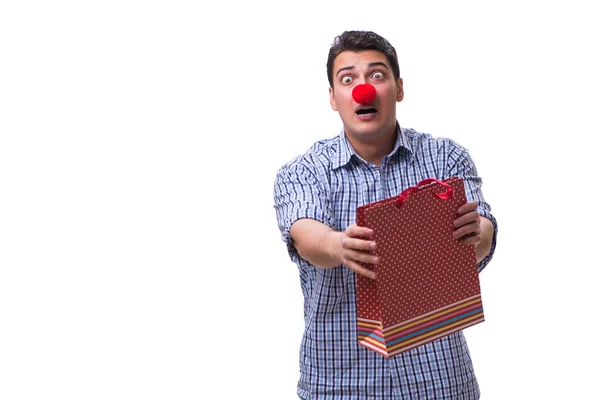 El hombre con una nariz roja divertida sosteniendo un regalo de bolsa de compras es —  Fotos de Stock