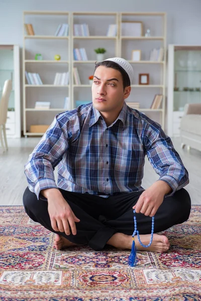 Young muslim man praying at home — Stock Photo, Image